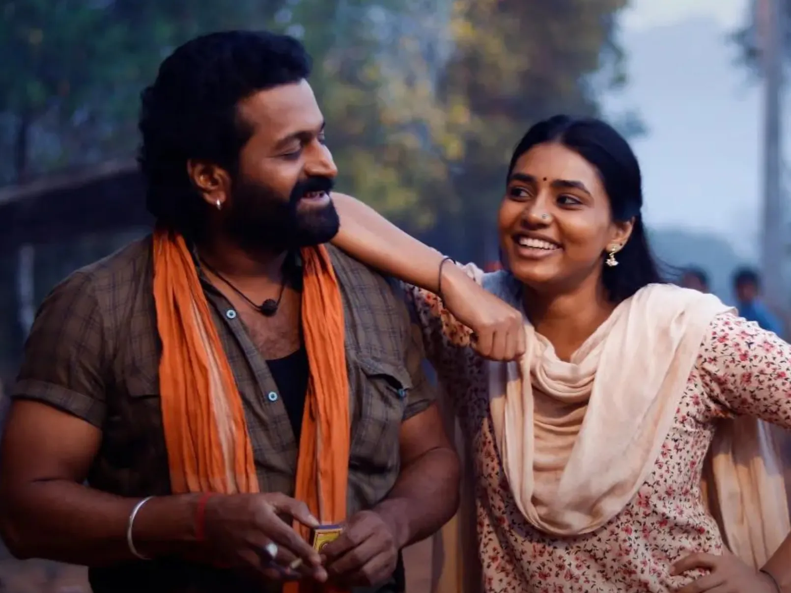 Rishab Shetty as Shiva and Sapthami Gowda as Leela in a warm village scene from Kantara