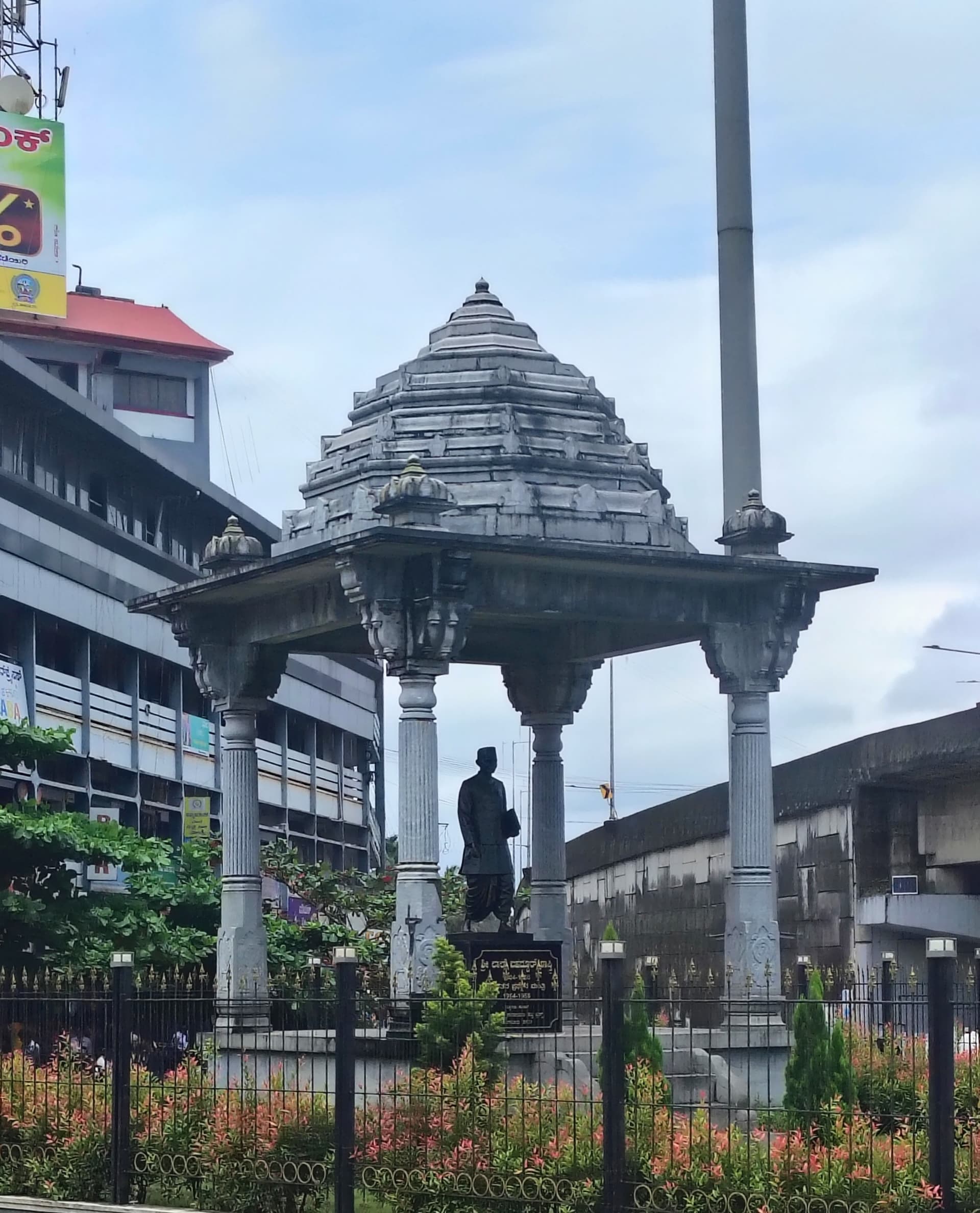 A statue under a stone pavilion at a town circle in Kundapura