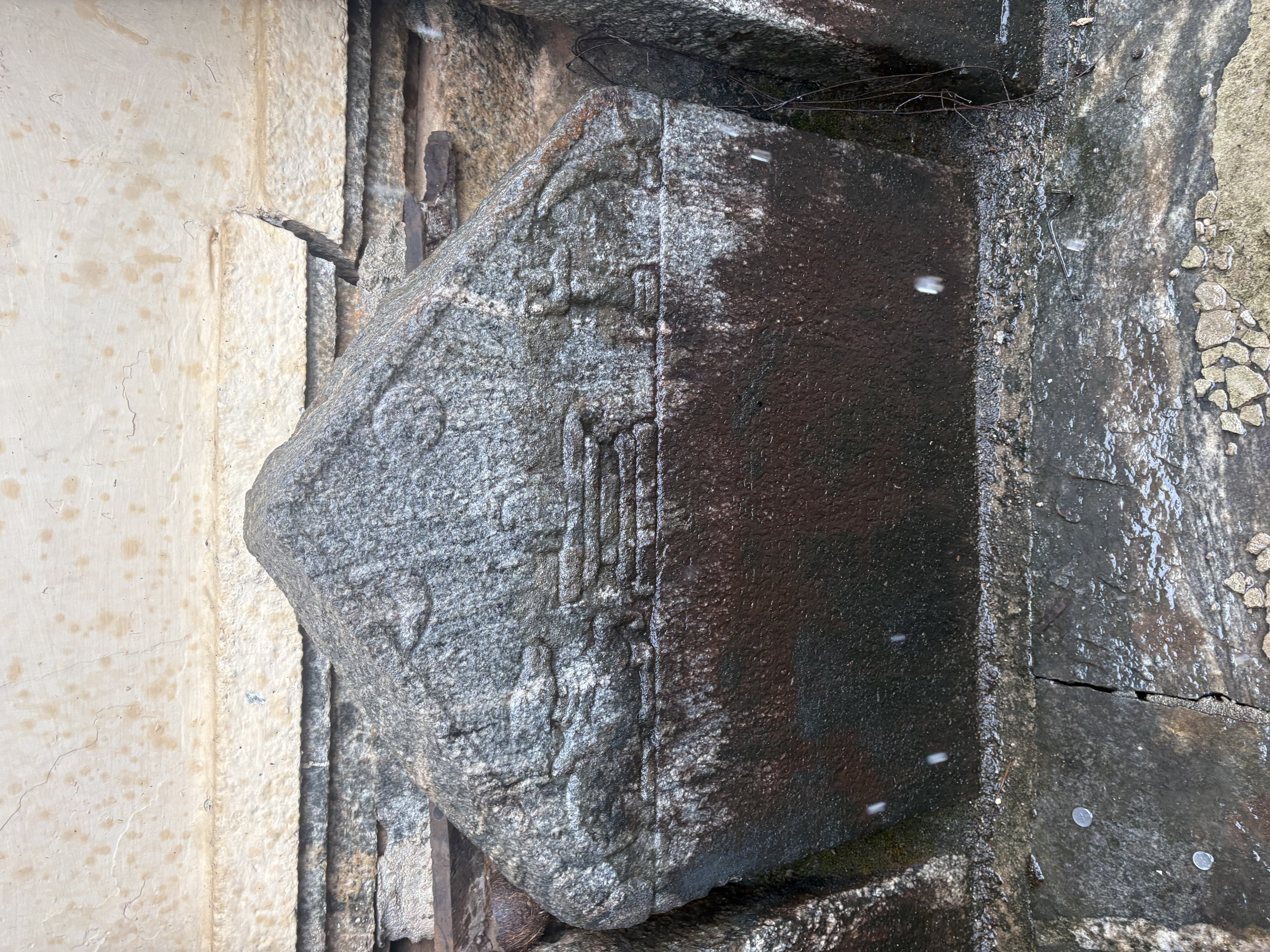 A figural hero-stone beside an engraved plaque